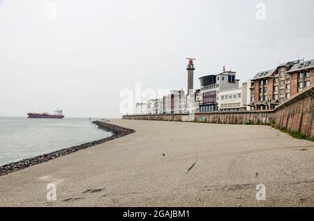 Vlisssingen, Niederlande, 24. Juli 2021: Asphalthang zwischen einer rauen Backsteinmauer und dem Meer als Teil der Uferpromenade der Stadt Stockfoto