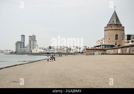 Vlisslingen, Niederlande, 24. Juli 2021: Blick entlang der Strandpromenade der Stadt mit dem historischen Gefangenenturm, einem Asphalthang und einer modernen Skyline Stockfoto