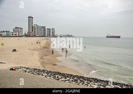 Vlisssingen, Niederlande, 24. Juli 2021: Teil der Strandpromenade der Stadt mit Sandstrand, moderner Skyline und Seeschiff Stockfoto