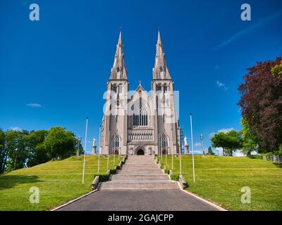 Das Äußere der römisch-katholischen St. Patrick's Cathedral in Armagh - aufgenommen an einem sonnigen Tag mit blauem Himmel und weißen Wolken Stockfoto