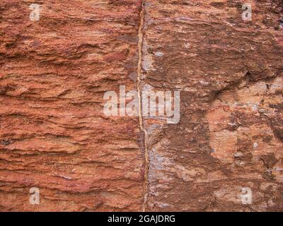 Rotes Lateritgestein bei Giants Causeway an der Antrim Coast in Nordirland, Großbritannien. Stockfoto