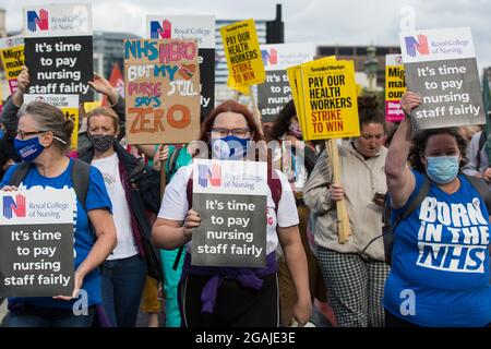 London, Großbritannien. Juli 2021. Mitarbeiter des NHS marschieren vom St. Thomas' Hospital zur Downing Street, um gegen die Empfehlung des NHS Pay Review Organs zu protestieren, die Gehälter für NHS-Mitarbeiter in England um 3 % zu erhöhen. Der protestmarsch wurde von Unite the Union, Das die ankommende NHS England-Chefin Amanda Pritchard aufgefordert hat, dafür zu sorgen, dass eine Erhöhung der NHS-Gehälter aus neuen Finanzmitteln und nicht aus bestehenden NHS-Budgets kommt, und von der in Kürze erwartet wird, dass sie ihren Mitgliedern eine beratende Abstimmung über Arbeitskampfmaßnahmen vorlegen wird. Kredit: Mark Kerrison/Alamy Live Nachrichten Stockfoto