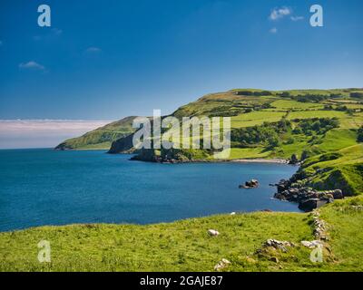 Von Torr Head aus, kristallklares blaues Wasser und grüne Hügel rund um die spektakuläre Antrim Causeway Coast in Nordirland, Großbritannien - aufgenommen an einem ruhigen, sonnigen Tag in Stockfoto