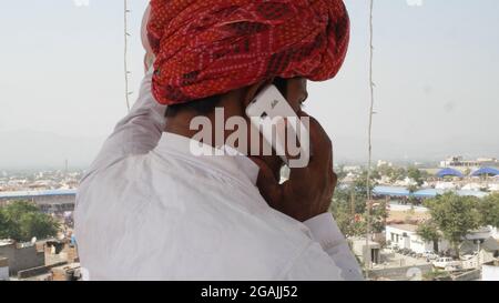 Rückansicht eines indischen Mannes in Nationalkleidung, der am Telefon sprach Stockfoto