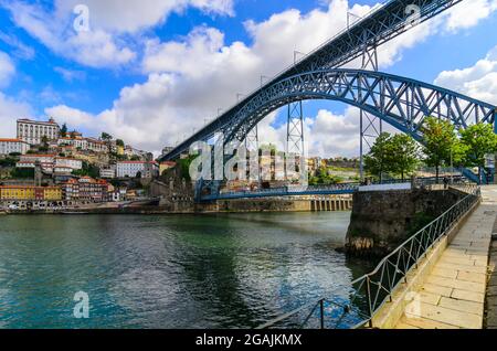 Porto, Portugal. Abenduntergang malerischer Blick auf die Altstadt mit antiken Häusern und roten Dächern in der Nähe der Brücke Ponte de Dom Luis am Fluss Douro. Stockfoto