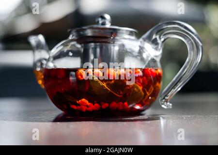 Glas-Teekannen mit heißem roten Beerentee, Nahaufnahme. Stockfoto