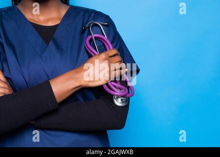 Crop African American junge Krankenschwester hält ein Stethoskop, isoliert auf weißem Hintergrund Stockfoto