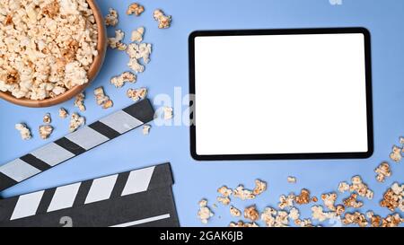 Modell für digitales Tablet, Klappbrett und Popcornschüssel auf blauem Hintergrund. Stockfoto