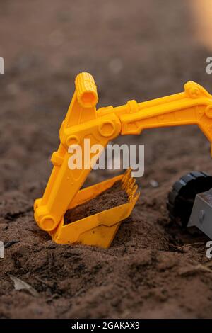 Gelbe und schwarze Farbe Spielzeug Bagger Miniatur auf dem Boden mit selektivem Fokus Stockfoto