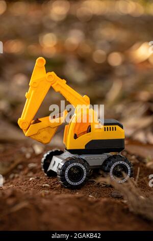 Gelbe und schwarze Farbe Spielzeug Bagger Miniatur auf dem Boden mit selektivem Fokus Stockfoto