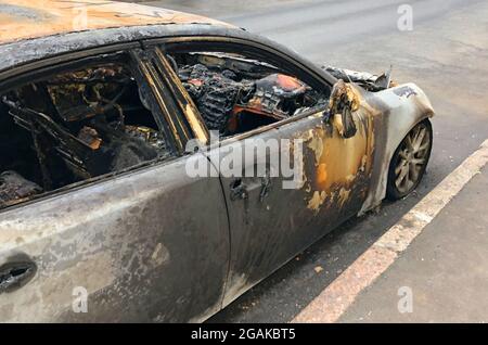 Ausgebranntes Auto am Straßenrand Stockfoto