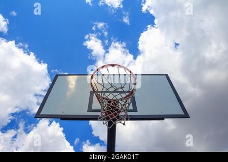 Basketballbrett, von unten gesehen, am bewölkten Himmel Stockfoto