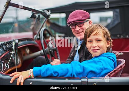 Towcester, Northamptonshire, Großbritannien. Juli 2021. Großvater und Enkel warten während des Classic Motor Racing Festivals auf dem Silverstone Circuit in ihrem Oldtimer (Foto: Gergo Toth / Alamy Live News) Stockfoto