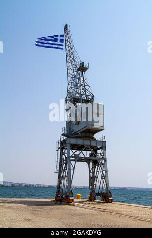 Thessaloniki, Griechenland, 15. Juli 2021. Griechische Flagge auf einem Kran im Hafen von Thessaloniki Stockfoto