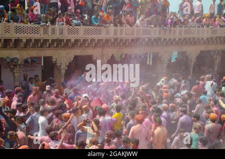 Pilger genießen es, beim Holi Festival in Mathura, Uttar Pradesh, Indien, mit Trommelschlägen zu tanzen. Stockfoto