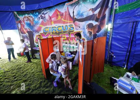 Besucher des Circus Extreme in Halifax warten auf die Impfung in einer Pop-up-Klinik für Impfungen der Covid-19, die im Festzelt des Zirkus eingerichtet wurde. Bilddatum: Samstag, 31. Juli 2021. Stockfoto