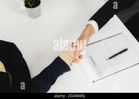 Erfolgreiche Verhandlungen und Geschäftsabschluß, Nahaufnahme von oben Handshake, glücklich mit Spaß mit Workmate und Partner, Unity Handshake-Konzept Stockfoto