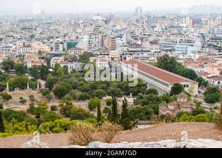 Blick auf die Stoa von Attalos, Odeon von Agrippa und das alte Stadtzentrum von Athen mit weißen Gebäuden an grau nebligen Tagen vom Areopagus - Hügel in der Nähe der Akropolis Stockfoto