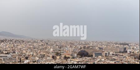 Panorama des Stadtzentrums von Athen überfüllte Straßen mit weißer Architektur an bewölktem, nebligen Tag. Blick von der Dachterrasse vom Filopappou Hill in der Nähe von Acrop Stockfoto