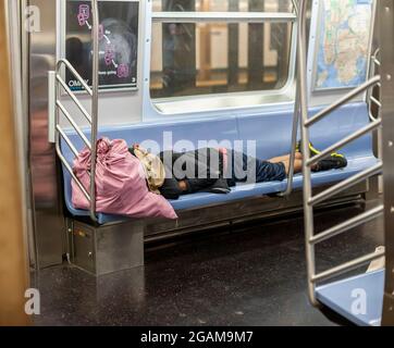 Ein Obdachloser schläft am Mittwoch, den 28. Juli 2021, in einem U-Bahn-Zug in New York. (© Richard B. Levine) Stockfoto