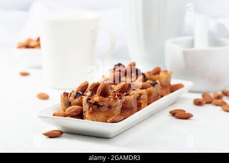 Kleine Kuchen mit Mandeln, Rosinen und Honig auf einem weißen Tisch. Stockfoto