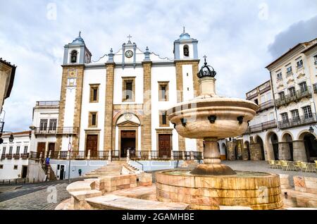 Brunnen und Santo Antao Kirche auf dem Giraldo Platz in Evora, Portugal Stockfoto