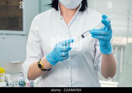 Der Arzt zieht ein Medikament aus einer Ampulle in eine Spritze Stockfoto
