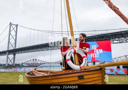 Paar im kleinen Holzboot starten Edinburgh International Film Festival, Port Edgar, Firth of Forth, Schottland, Großbritannien Stockfoto