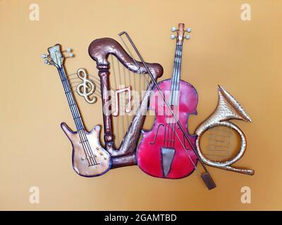 Miniaturmodelle von Musikinstrumenten. Die Modelle sind aus Eisen gefertigt und dienen als Dekoration an der Wand. Stockfoto