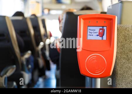 Orangefarbene Fahrkartenentwertung in einem modernen Bus mit öffentlichen Verkehrsmitteln. Stockfoto