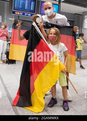 31. Juli 2021, Hessen, Frankfurt/Main: Der Rudersilbermedaillengewinnerin Jonathan Rommelmann in Tokio wird bei seiner Rückkehr von den Olympischen Spielen von Kindern seiner Familie am Flughafen begrüßt. Foto: Boris Roessler/dpa Stockfoto