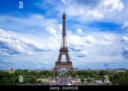 Ein atemberaubender Blick auf den Eiffelturm unter einem blauen Himmel mit flauschigen Wolken in Paris, der seine Pracht tagsüber in Frankreich zeigt Stockfoto