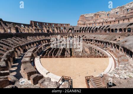 Erkunden Sie die antike Architektur des Kolosseums in Rom an einem klaren Tag mit Besuchern, die die historische Arena beobachten. Italien Stockfoto