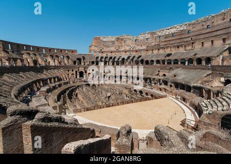 Erkunden Sie die antike Architektur des Kolosseums in Rom an einem klaren Tag mit Besuchern, die die historische Arena beobachten. Italien Stockfoto