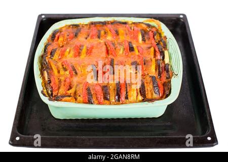 Metallschale mit gerade gebackener vegetarischer Ratatouille aus Zucchini, Auberginen, Tomaten, Zwiebeln, Kartoffeln, Und eine spezielle Sauce, isoliert auf einem wh Stockfoto