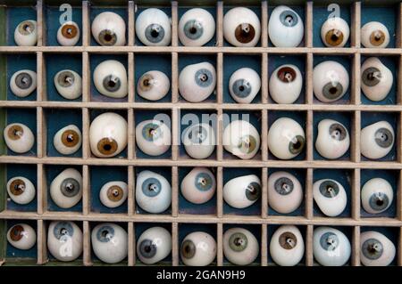 Sammlung künstlicher Augen in einem geteilten Kasten, in dem verschiedene Farben und Größen für verschiedene Anwendungen dargestellt werden Stockfoto