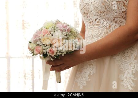 Braut in weißem Kleid mit dem Strauß in den Händen. Frau bereit für die Ehe Stockfoto
