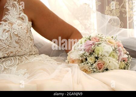 Braut in weißem Kleid mit dem Strauß in den Händen. Frau bereit für die Ehe Stockfoto