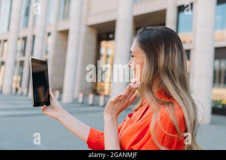 Kaukasisches Mädchen mit Tablet und im Gespräch auf Video-Chat und sagen Hallo. Stockfoto