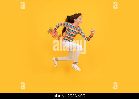 Glücklich energisch teen Mädchen Skateboarder springen mit Penny Board Skateboard, Pennyboard Stockfoto