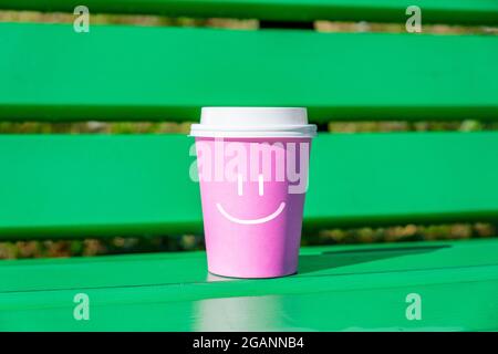 Konzept der guten Laune und positiv mit Smiley Gesicht auf Tasse Einweg-Kaffee. Stockfoto