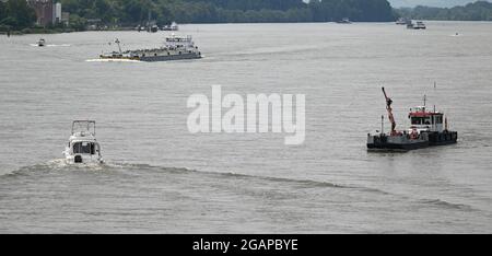 Wiesbaden Schierstein, Deutschland. Juli 2021. Ein Bergungsschiff (r), Vergnügungsboote und Frachtschiffe befinden sich auf dem Rhein. Da Corona das Reisen schwieriger gemacht hat, ist es im Sommer auf den Flüssen überfüllt. Vor allem Sportbootfahren, Jetski und Stand-Up Paddling (SUP) werden seit Jahren immer beliebter. Und das nicht nur am Rhein und Main, sondern auch an den anderen Flüssen. (To dpa 'Trubel und Trouble auf Rhein und Main - Jetski-Fahrer in der Kritik') Quelle: Arne Dedert/dpa/Alamy Live News Stockfoto