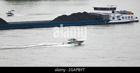 Wiesbaden Schierstein, Deutschland. Juli 2021. Zwei Vergnügungsboote passieren ein Frachtschiff auf dem Rhein. Da Corona das Reisen erschwert hat, ist es im Sommer auf den Flüssen immer mehr voll geworden. Vor allem Sportbootfahren, Jetski und Stand-Up Paddling (SUP) werden seit Jahren immer beliebter. Und das nicht nur am Rhein und Main, sondern auch an den anderen Flüssen. (To dpa 'Trubel und Trouble auf Rhein und Main - Jetski-Fahrer in der Kritik') Quelle: Arne Dedert/dpa/Alamy Live News Stockfoto