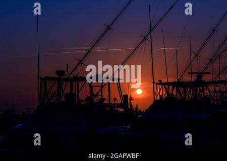 Silhouette kommerzieller Fischerboote, die an der Marina in Cape Hatteras, North Carolina, angedockt sind Stockfoto