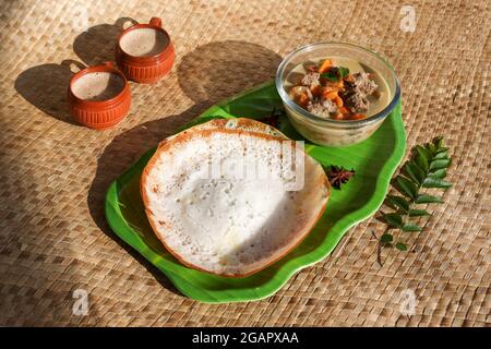 Appam, Hoppers und Hammelfleisch Eintopf Kerala Frühstück Essen und indische Milch Tee Chai, christian Frühstück Indien Sri Lanka Tamil Nadu fermentierten Reis Pfanne Kuchen. Stockfoto