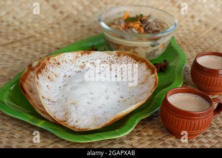 Appam, Hoppers und Hammelfleisch Eintopf Kerala Frühstück Essen und indische Milch Tee Chai, christian Frühstück Indien Sri Lanka Tamil Nadu fermentierten Reis Pfanne Kuchen. Stockfoto