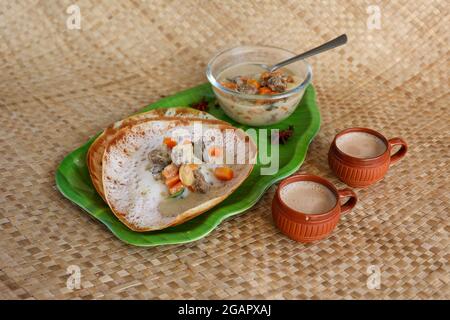 Appam, Hoppers und Hammelfleisch Eintopf Kerala Frühstück Essen und indische Milch Tee Chai, christian Frühstück Indien Sri Lanka Tamil Nadu fermentierten Reis Pfanne Kuchen. Stockfoto