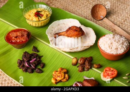 Appam mit Hammeleintopf nicht-vegetarische Sadhya Indisches Essen für Onam Sadya Weihnachten Ostern Feier Kerala Indien Sri Lanka hoppers Rindfleisch braten Fisch Stockfoto