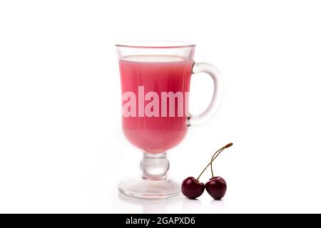Milchcocktail mit Kirsche in klarem Glas und Beeren auf hellem Hintergrund. Stockfoto