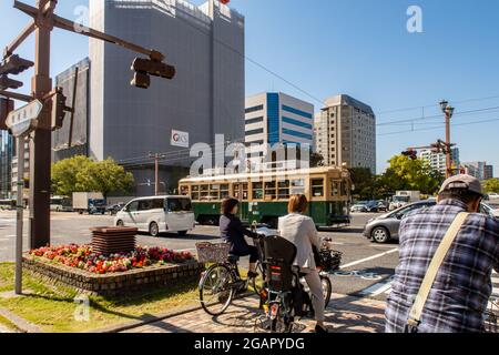 HIROSHIMA, Japan, 31.10.2019. Straßenkreuzung in Hiroshima mit dem berühmten alten grünen Straßenbahnwagen Nr. 651, der Atombomben überlebte. Stockfoto